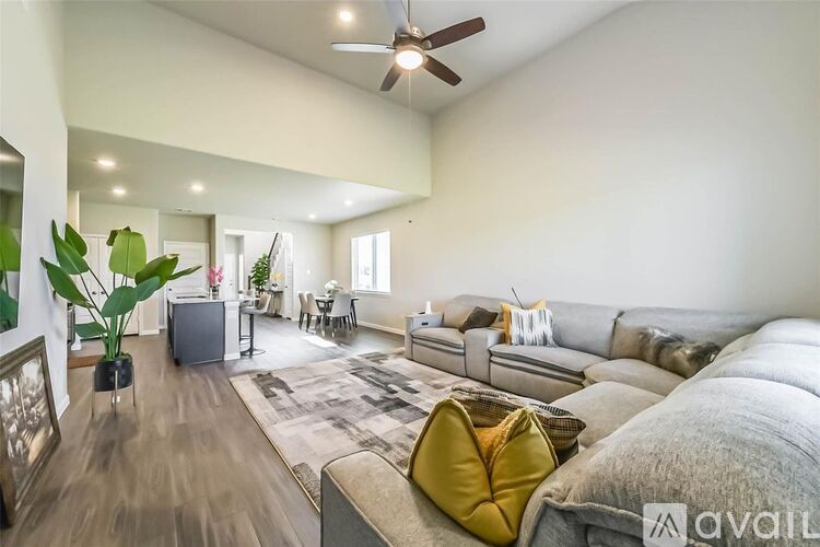 A living room with a grey sofa and a yellow pillow.