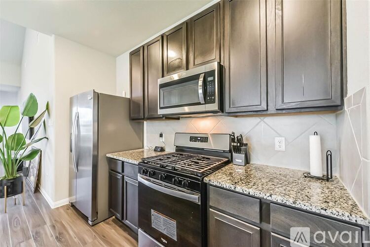 A kitchen with dark brown cabinets and stainless steel appliances.