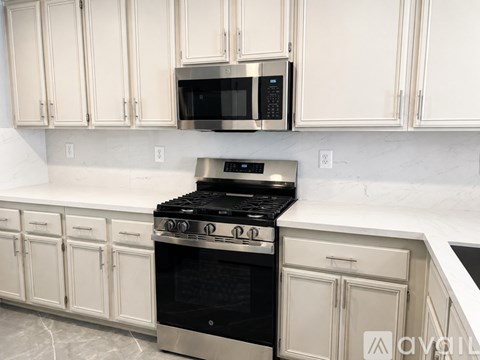 A kitchen with a black stove top oven and white cabinets.
