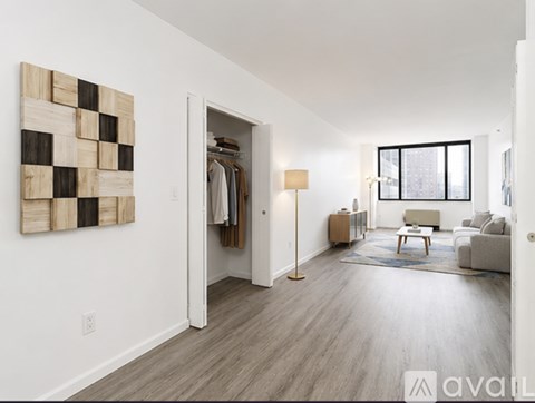 A modern living room with a large painting on the wall and a wooden floor.