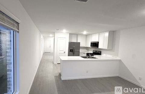 A modern kitchen with white cabinets and appliances.