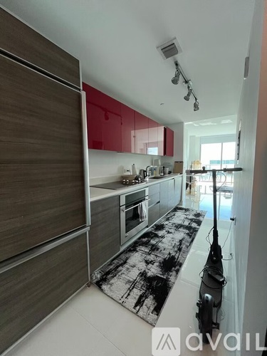A kitchen with a black and white rug on the floor.