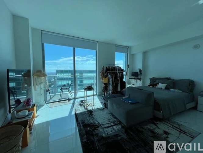 A bedroom with a large bed and a view of the ocean through the windows.