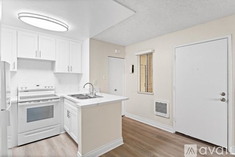 A kitchen with white appliances and cabinets.
