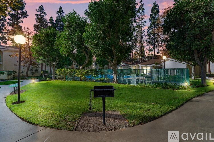 A park with a bench and trees in the background.