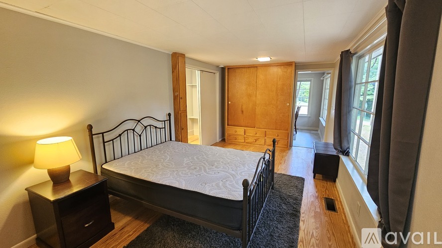 A bedroom with a bed, nightstand, and window.