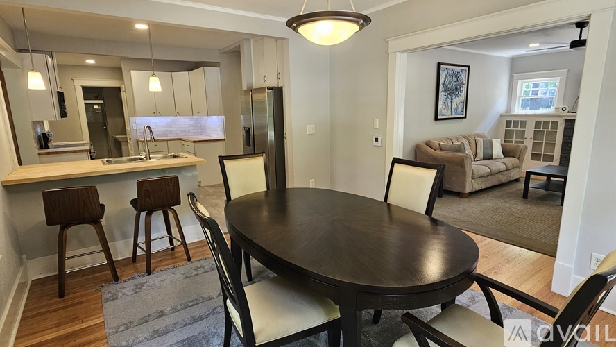 A modern dining room with a round table and chairs.