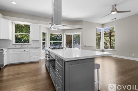 A modern kitchen with white cabinets and a large island.