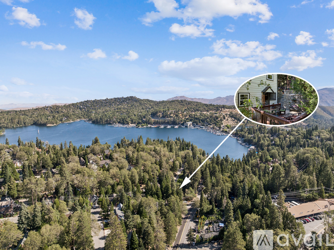 A bird's eye view of a lake surrounded by trees with a house in the inset picture.