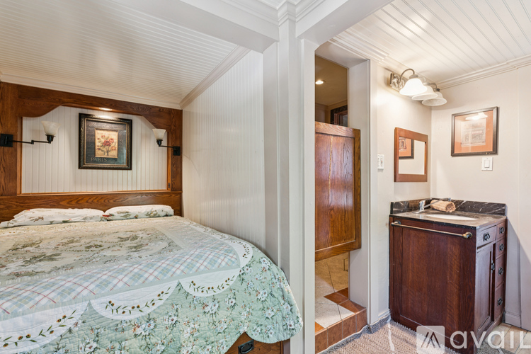 A bedroom with a bed and a wooden cabinet.
