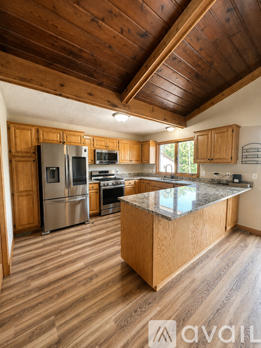 A kitchen with wooden cabinets and a granite countertop.