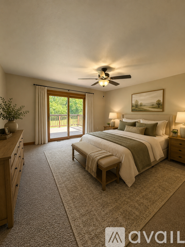 A bedroom with a large bed, a ceiling fan, and a view of the backyard through the sliding glass door.