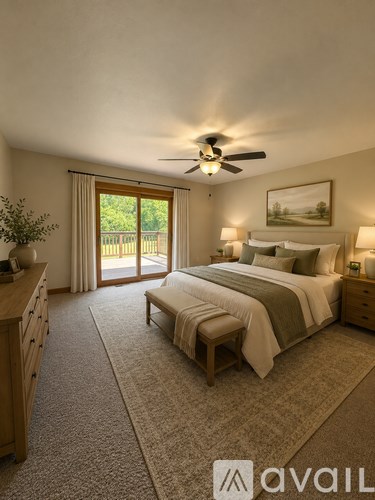 A bedroom with a large bed, a ceiling fan, and a view of the backyard through the sliding glass door.