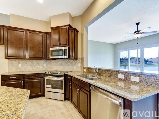 A kitchen with brown cabinets and a granite countertop.