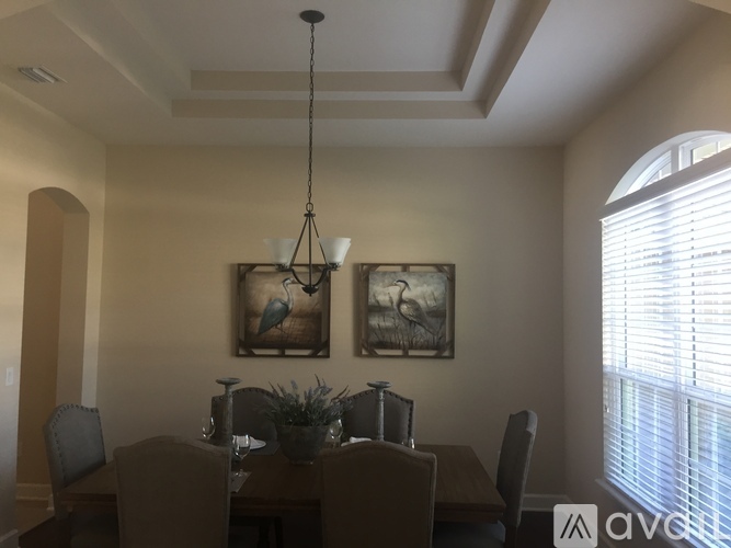 A dining room with a wooden table and chairs.