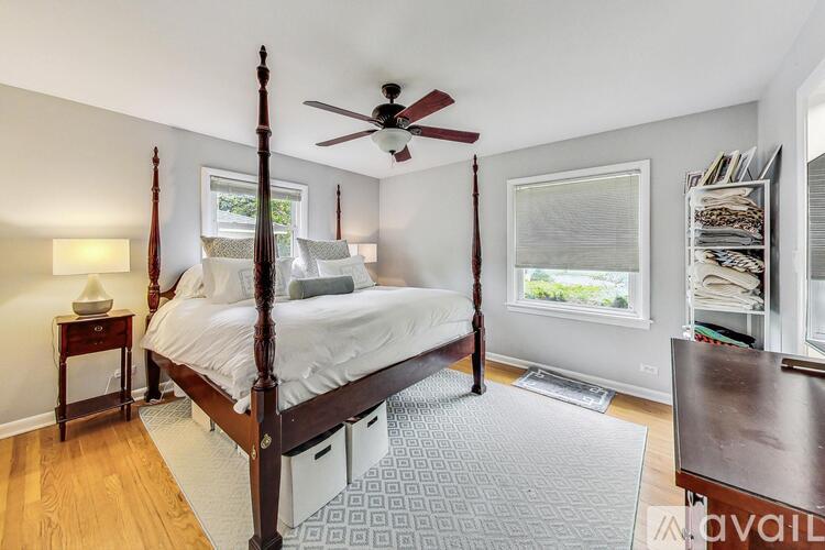 A bedroom with a four poster bed and a ceiling fan.
