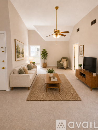 A living room with a couch, a coffee table, a ceiling fan, and a television.