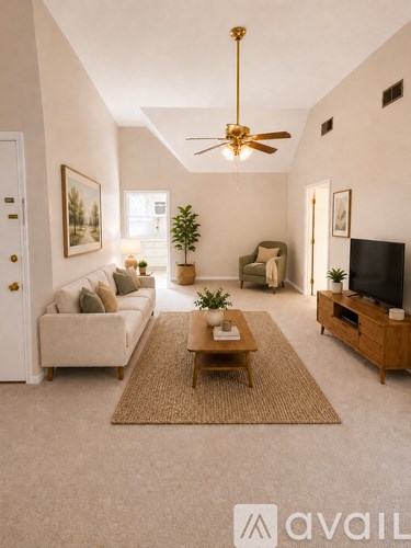 A living room with a couch, a coffee table, a ceiling fan, and a television.