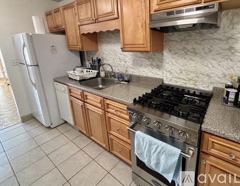 A kitchen with a stove, sink, and refrigerator.