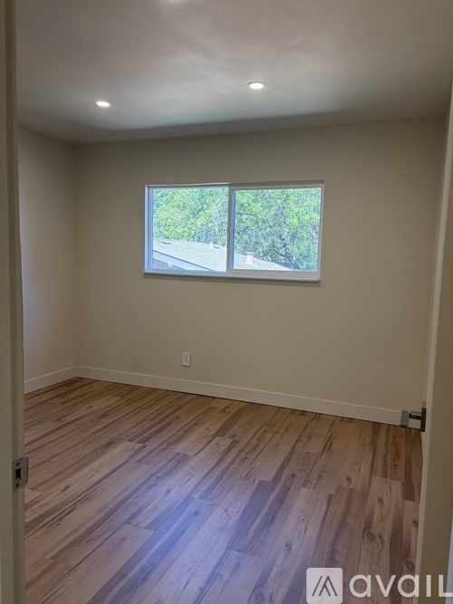 A room with wooden flooring and a window.