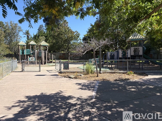 A playground with a swing set and a fence.