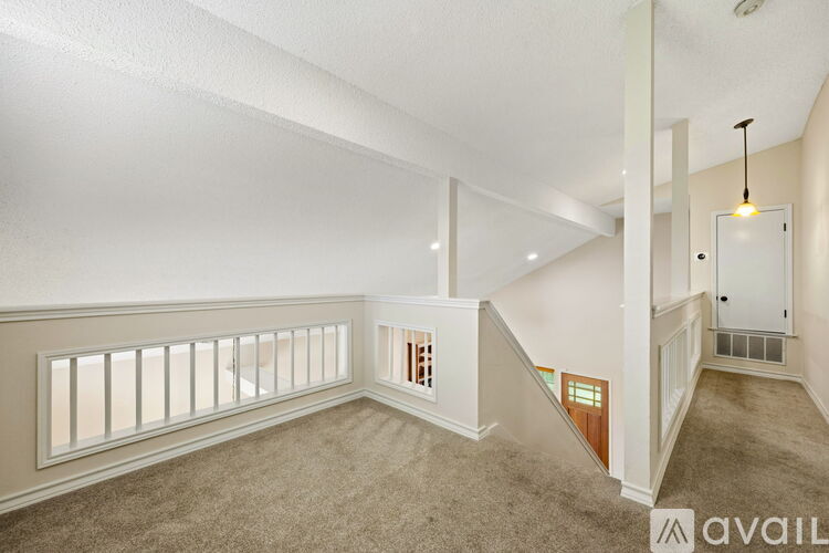A spacious room with a staircase leading to the second floor.