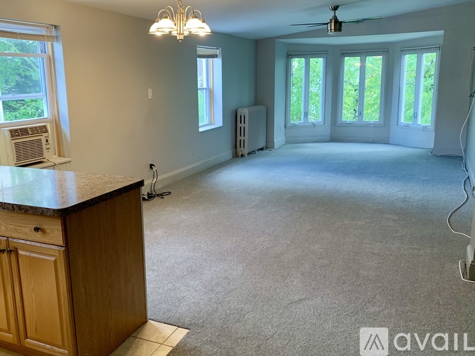 A spacious room with a counter, a fan, and a window.