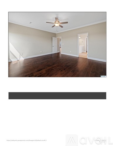 A spacious room with a ceiling fan and hardwood floors.