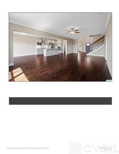 A spacious living room with hardwood floors and a ceiling fan.
