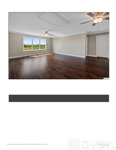 A spacious room with a ceiling fan and wooden flooring.