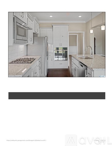 A modern kitchen with white cabinets and appliances.