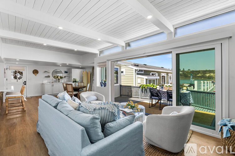 A living room with a couch and a chair with a view of the outside.