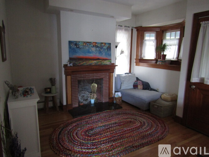 A living room with a fireplace and a painting on the wall.