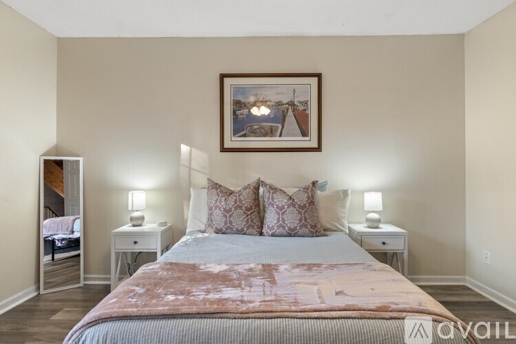 A bedroom with a large bed and a framed picture on the wall.