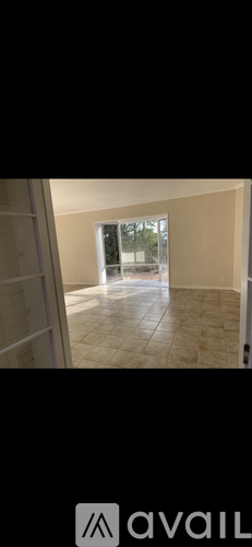 A room with a tiled floor and a window showing trees outside.