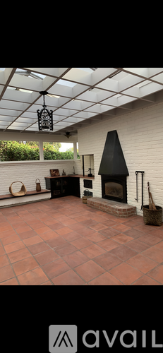 A patio with a fireplace and a hanging light fixture.