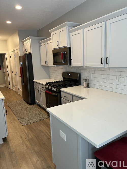 A kitchen with white cabinets and a white counter top.