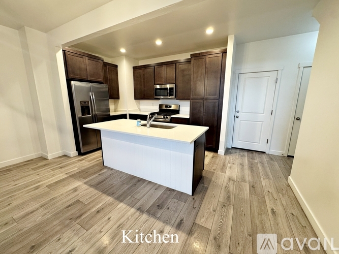 A kitchen with wooden floors and white walls.