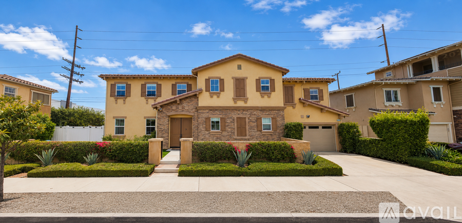 A house with a brown front yard and a white fence.