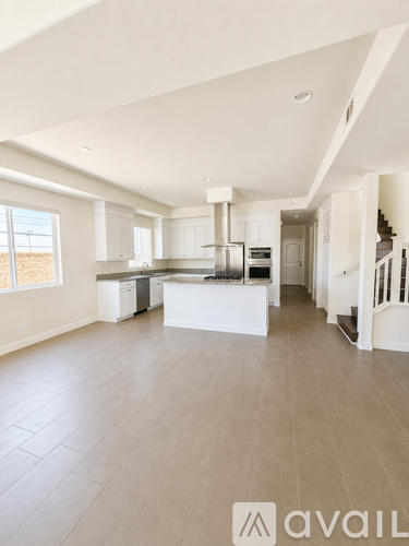 A spacious kitchen with white cabinets and a central island.
