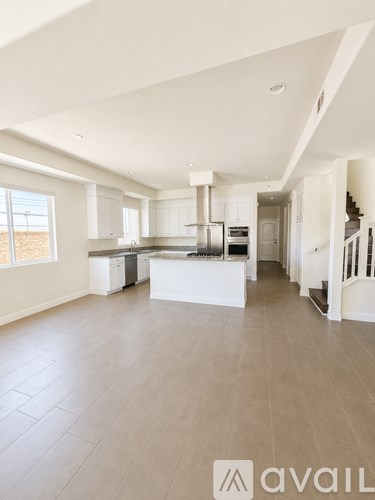 A spacious kitchen with white cabinets and a central island.