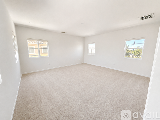 A white room with carpeted floor and two windows.