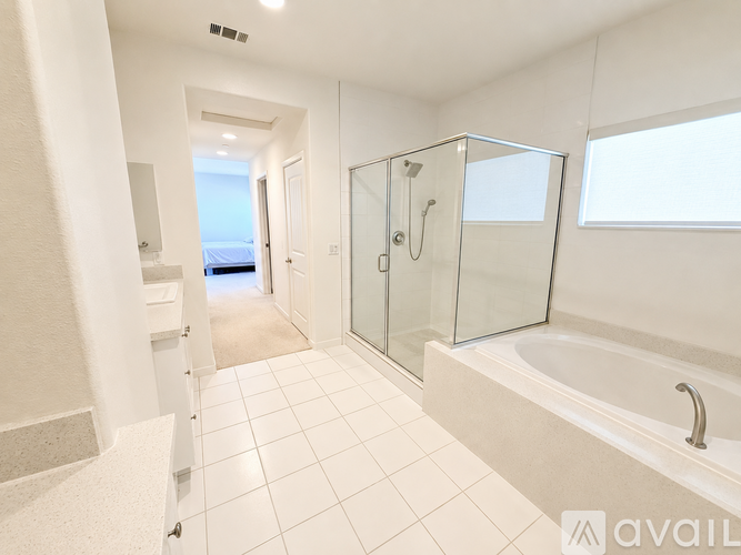 A bathroom with a glass shower stall and a bathtub.