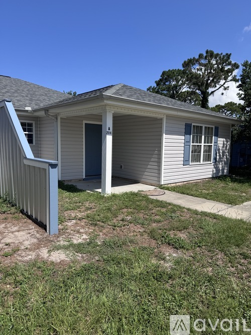 A small house with a grey roof and a blue door.