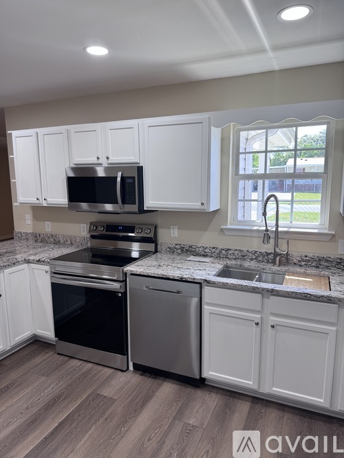 A kitchen with white cabinets and a granite countertop.
