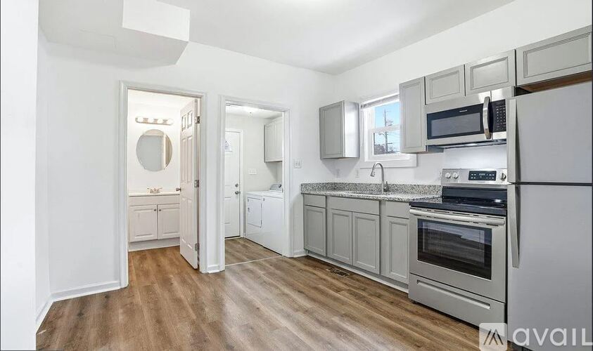 A kitchen with white cabinets and a wooden floor.