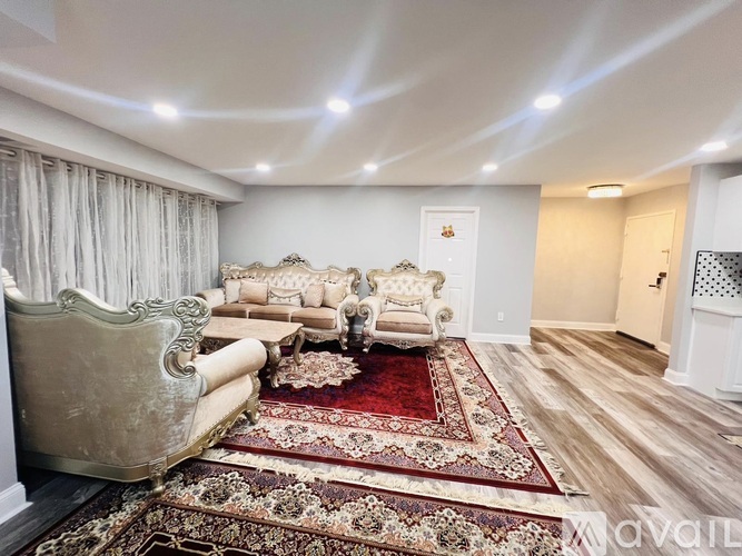 A living room with a large rug and a sofa.