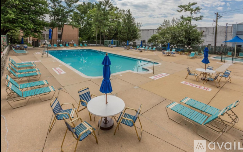 A pool area with chairs and a table.
