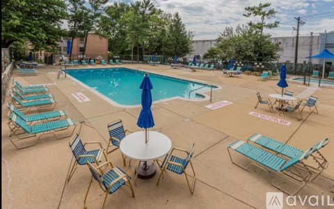 A pool area with chairs and a table.