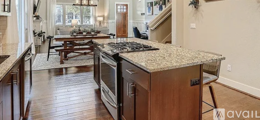 A kitchen with a granite countertop and a stove top oven.